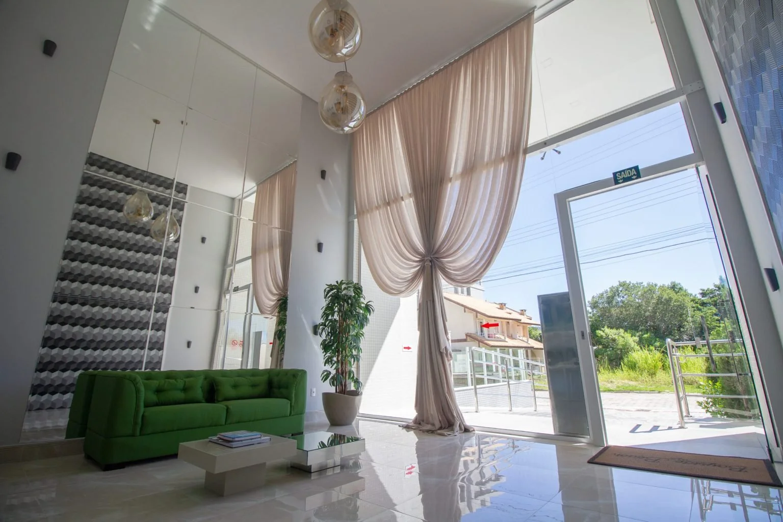 Portas e painéis de vidro em uma sala com pé-direito alto
