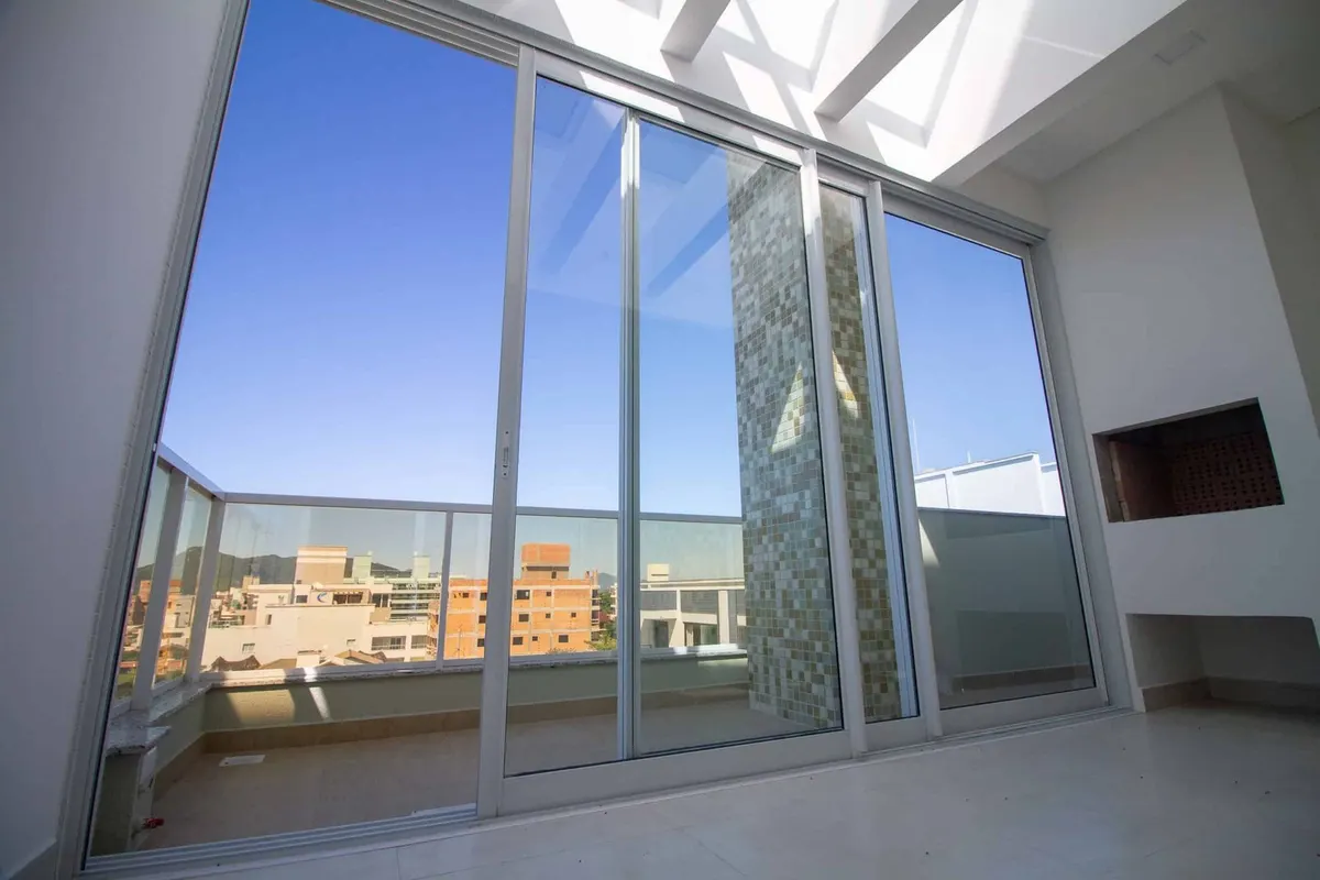 Portas de alumínio branco e vidro em um ambiente com pé-direito alto