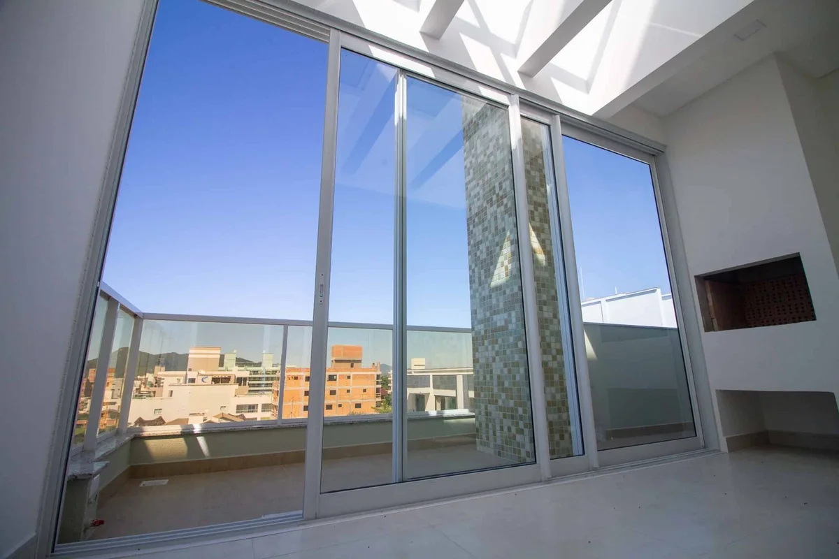 Portas de alumínio branco e vidro em um ambiente com pé-direito alto