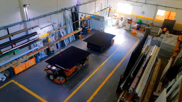 Área de fabricação da Inovar, com bancadas de trabalho e perfis de alumínio